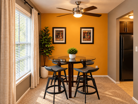A dining room with a table and chairs.