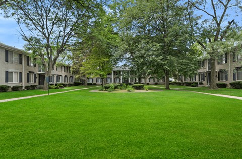 A grassy area in front of apartment buildings.