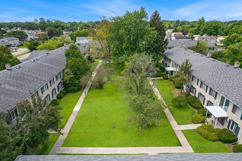 A bird's eye view of a green lawn surrounded by buildings.