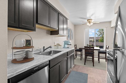 A kitchen with black cabinets and a marble countertop.