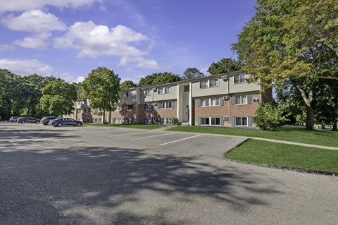 A parking lot in front of a residential building.