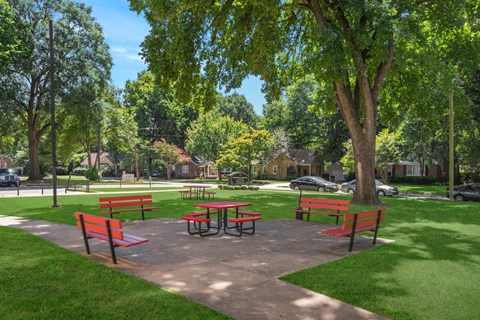 A park with picnic tables and benches.