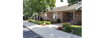 a brick house with a sidewalk in front of it