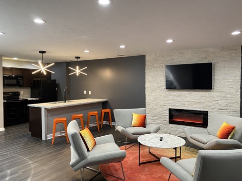 A modern living room with grey chairs and a fireplace.