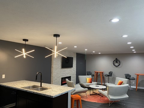 A modern kitchen with a black countertop and a fireplace.