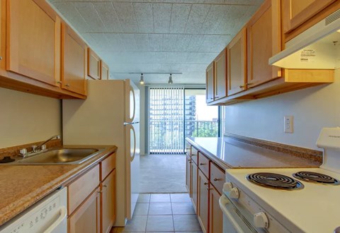 A kitchen with wooden cabinets and a white stove top oven.