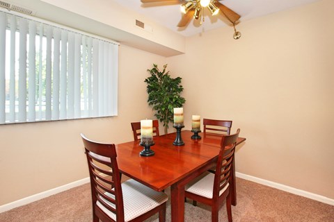 A dining room with a wooden table and chairs.