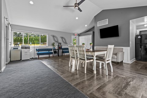 A modern dining room with a large table and chairs.