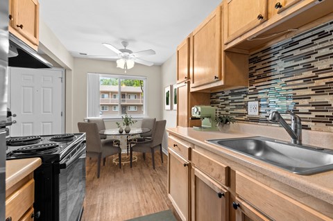 A kitchen with wooden cabinets and a black stove top oven.