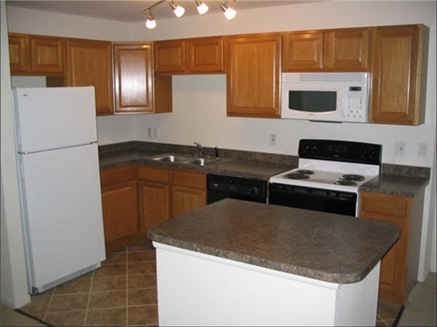 A kitchen with a white refrigerator and a black stove top oven.