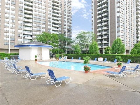 a swimming pool with a bunch of chairs around it