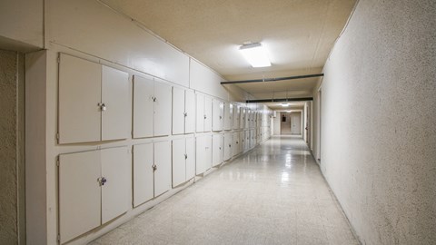 A long hallway with white lockers on the side.
