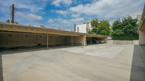 A parking lot with a building in the background and numbered parking spaces.