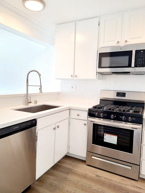 a kitchen with stainless steel appliances and white cabinets