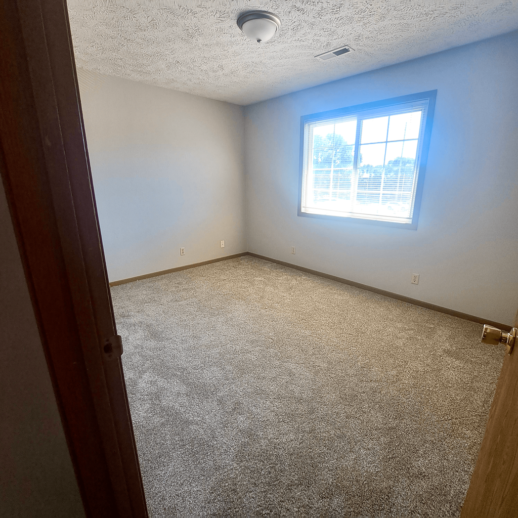 a room with a carpeted floor and a window