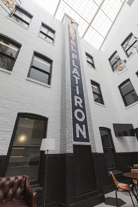 A white brick building with a black sign that says "ELEVATOR".