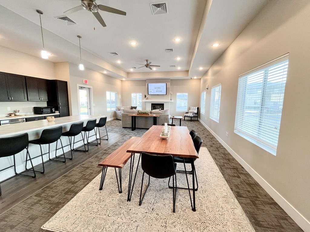a large dining room with a table and chairs and a kitchen with a television