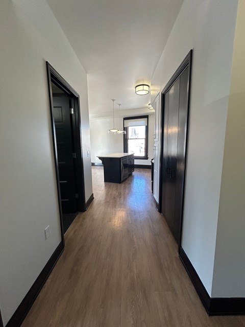 A long hallway with a table and chairs in the distance.