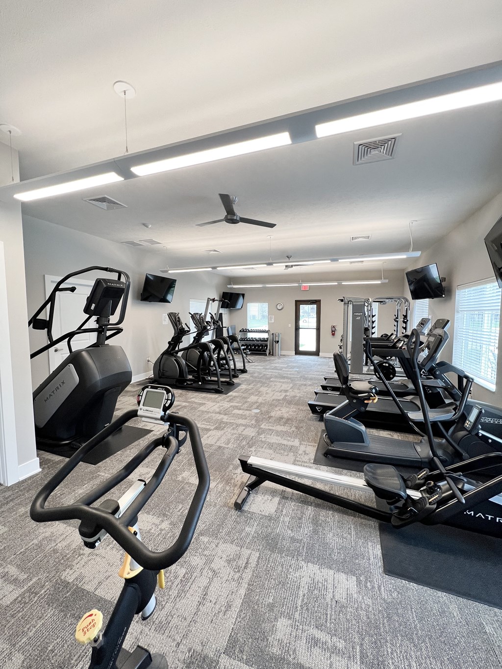 a gym with treadmills and other exercise equipment in a building