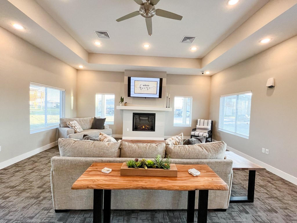a living room with couches and a table in front of a fireplace