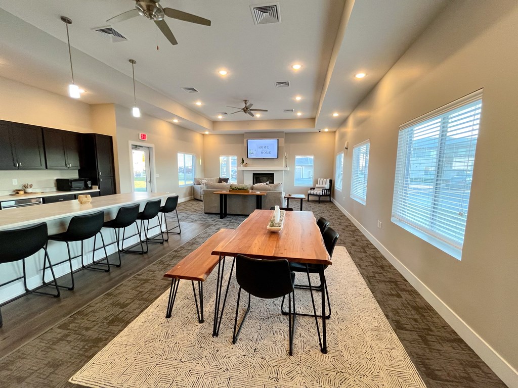 a conference room with a wooden table and chairs and a kitchen with a large window