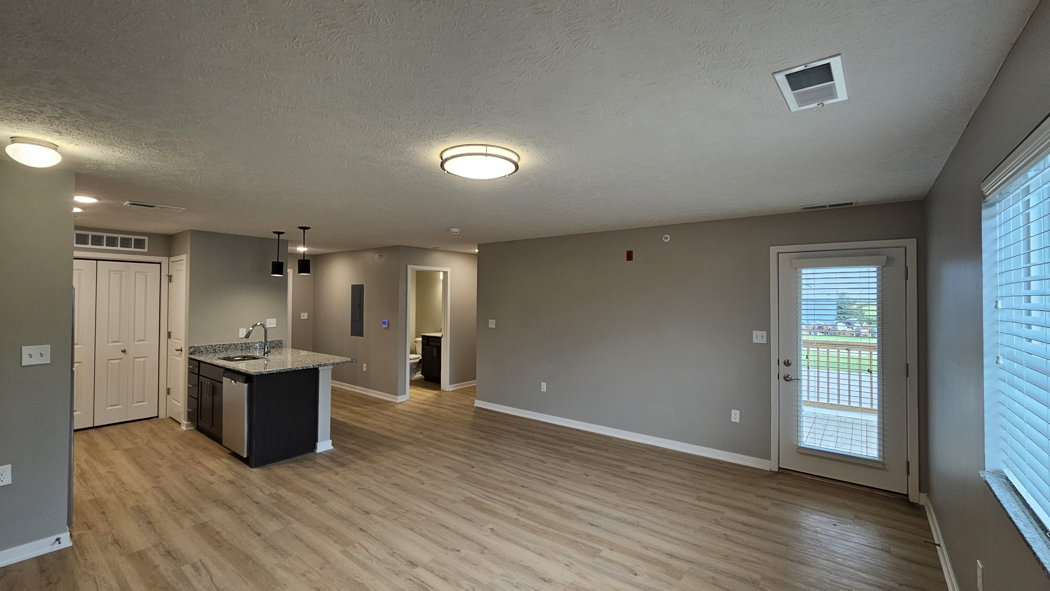 A spacious room with a kitchenette and a view.