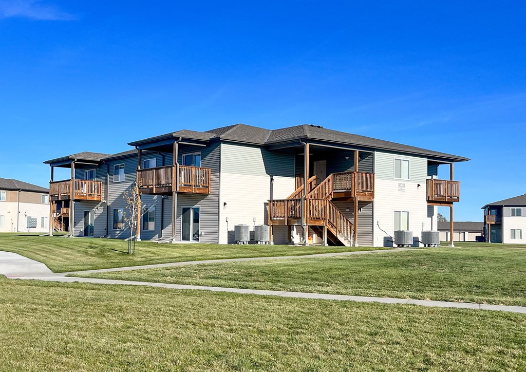 a house with wooden balconies on the side of a field