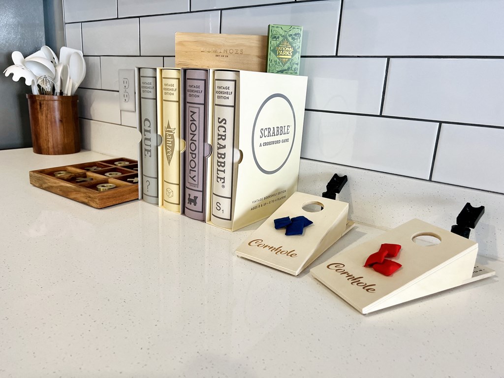 a row of books on a counter next to a shelf of chess pieces