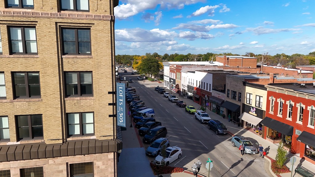 A street view of a town with cars parked on the side of the road.