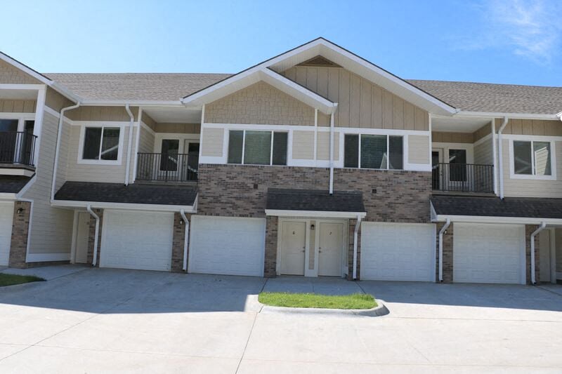 a white and brown house with a garage door