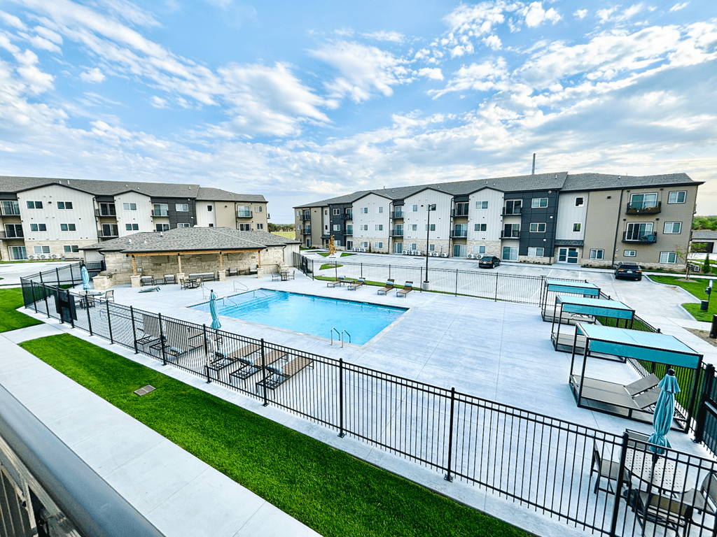 an outdoor swimming pool with apartments in the background
