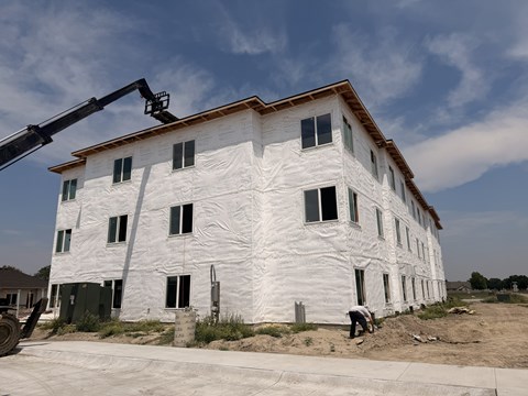 A building under construction with a crane on the left side.