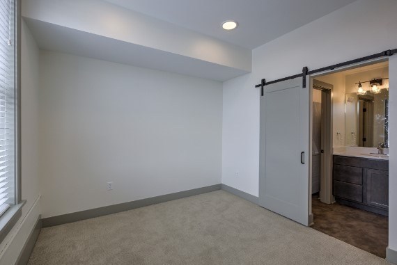A spacious room with a sliding door leading to a bathroom.