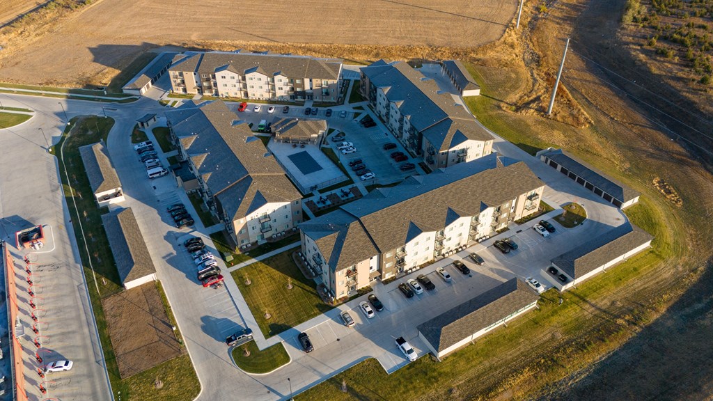 A large, modern building with a parking lot in front.