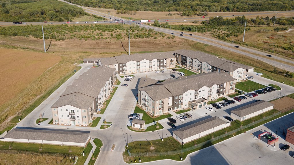 A large apartment complex with a parking lot in front.