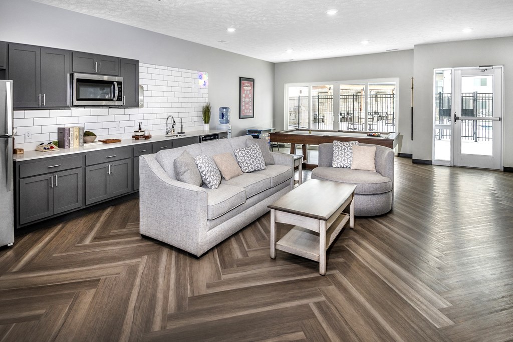 A modern living room with a grey couch and a wooden floor.