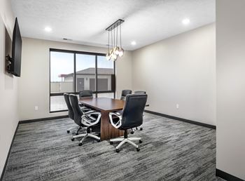 A conference room with a large table and chairs.