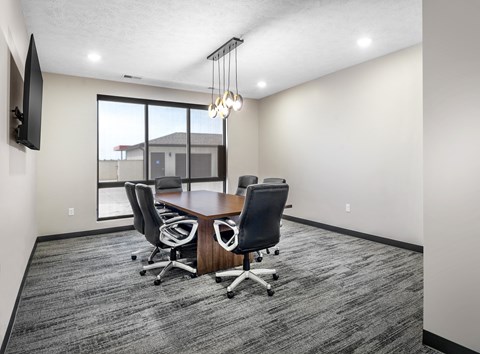 A conference room with a large table and chairs.
