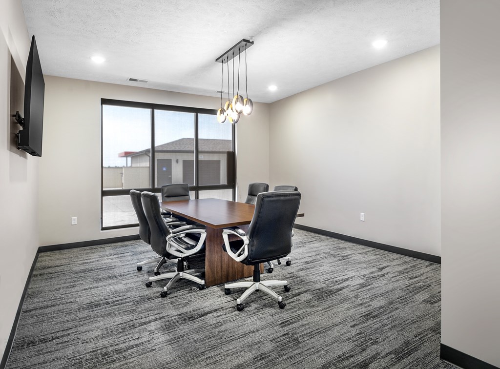 A conference room with a large table and chairs.