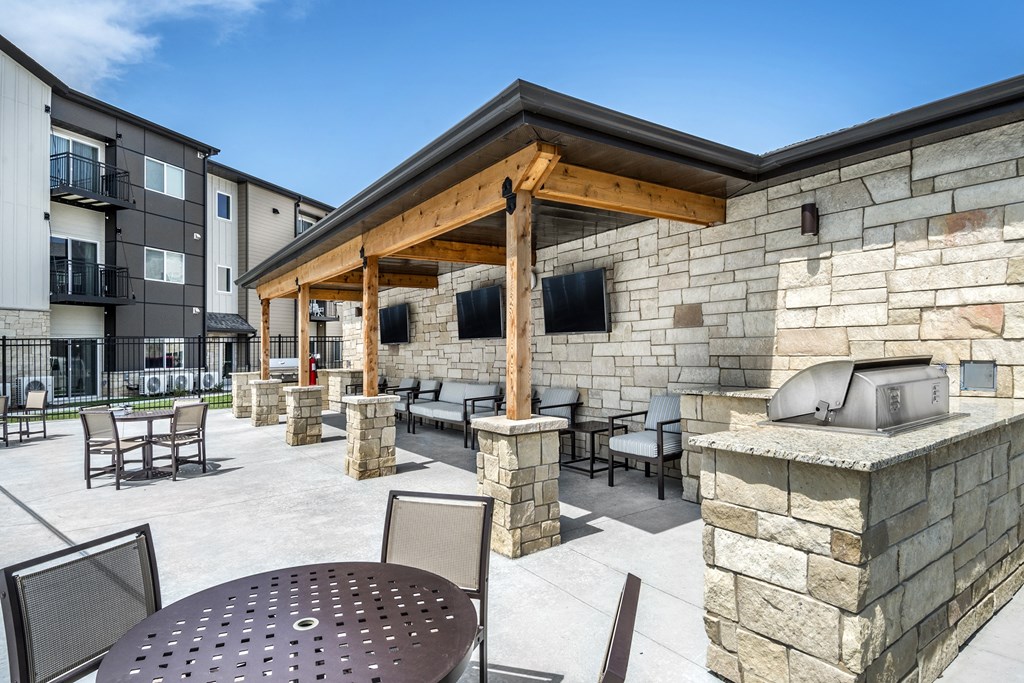 A patio with a table and chairs is surrounded by stone walls.