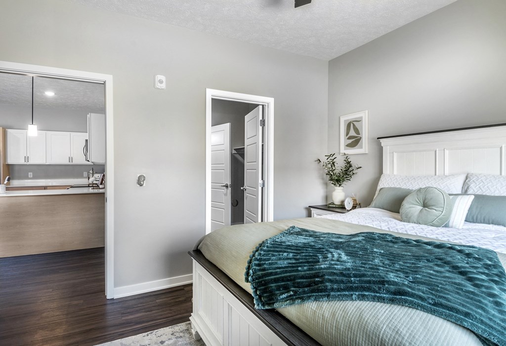 A bedroom with a bed, a dresser, and a mirror.