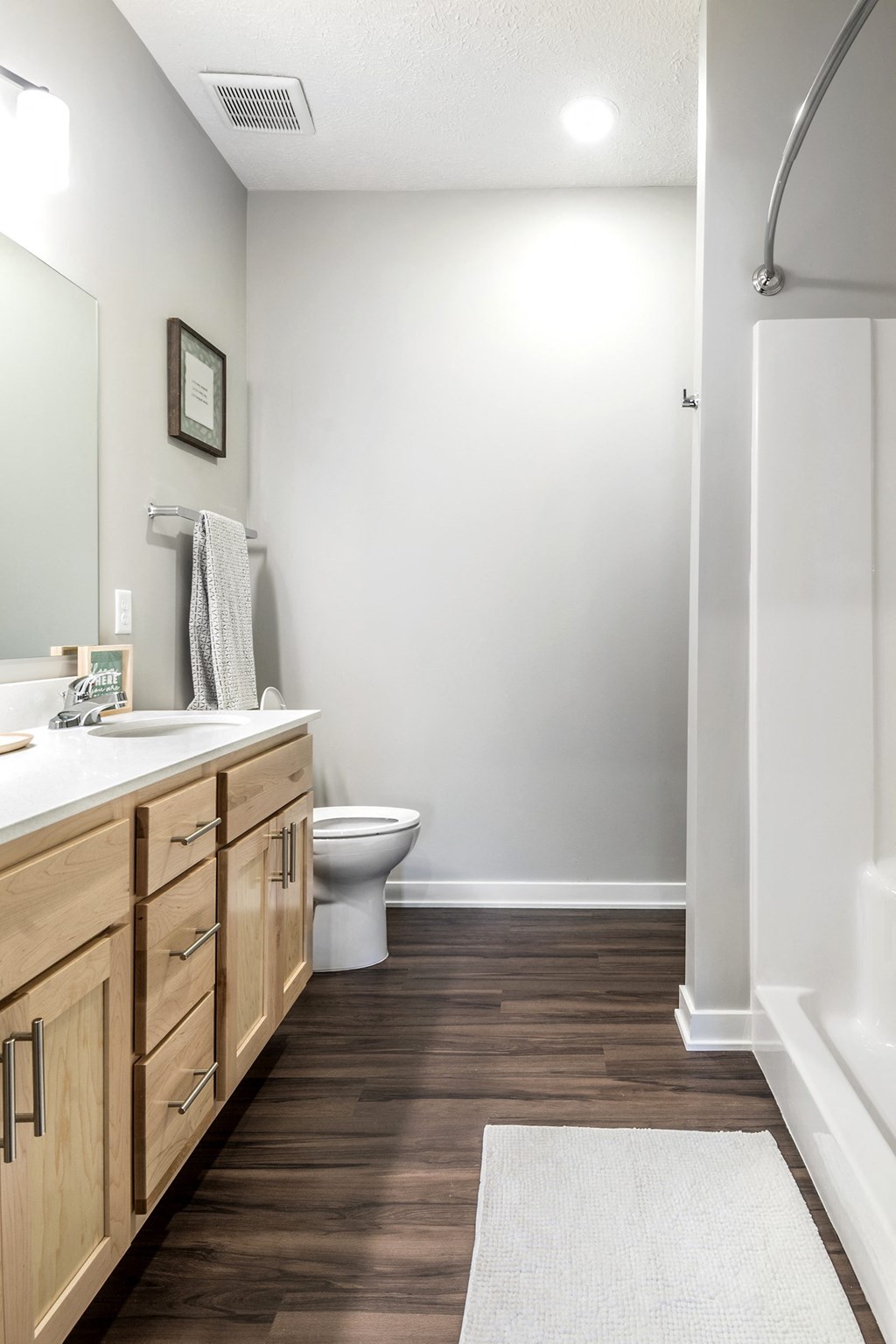 A bathroom with a toilet, sink, and mirror.