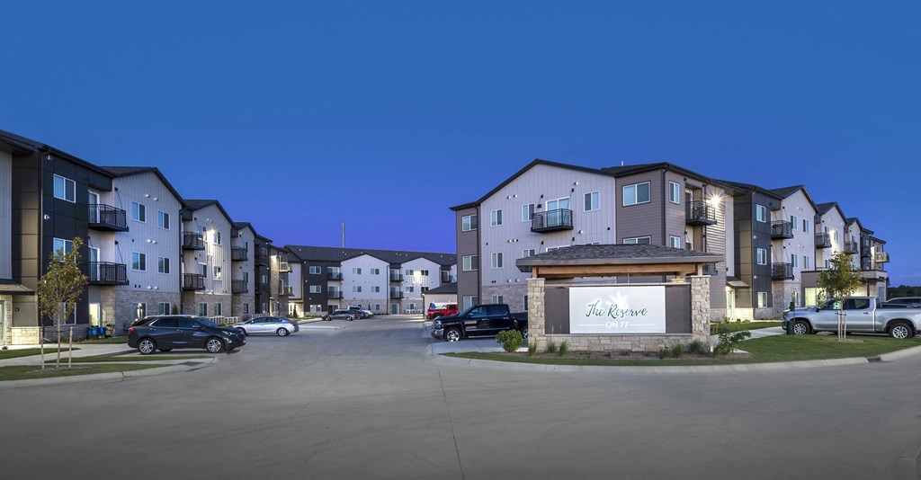 The entrance to a residential complex called The Grove is shown at dusk.