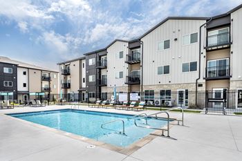 A swimming pool is surrounded by apartment buildings.