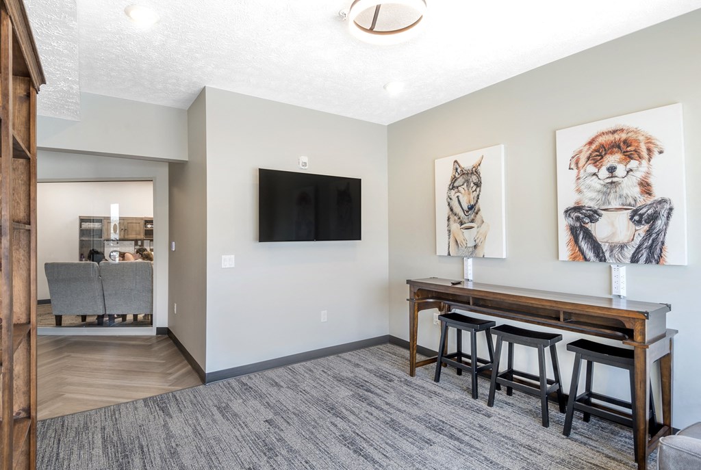 A living room with a grey carpet and a wooden bar.