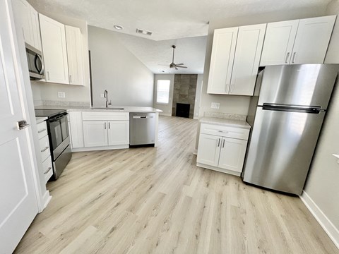 A kitchen with a refrigerator on the right side.