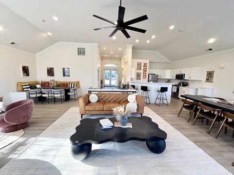 A modern living room with a black coffee table in the center.