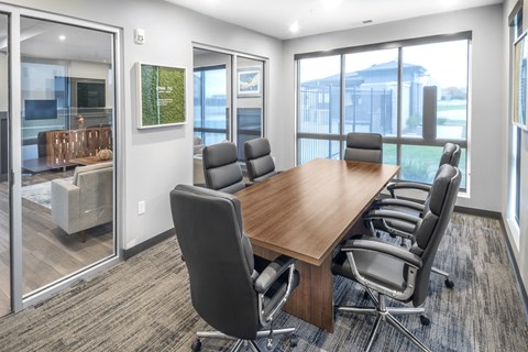 A conference room with a long table and chairs.