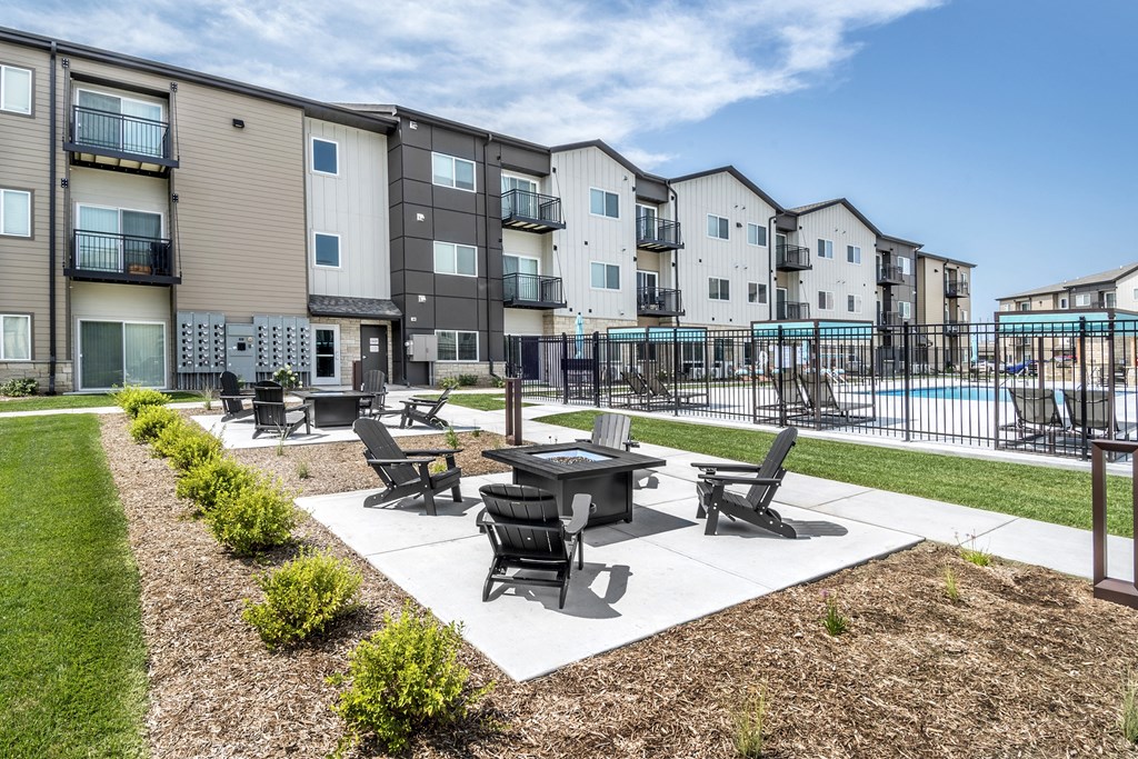 A sunny day at a residential complex with a pool and a patio area.