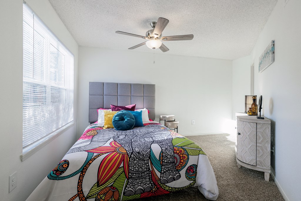 a bedroom with a large bed and a ceiling fan